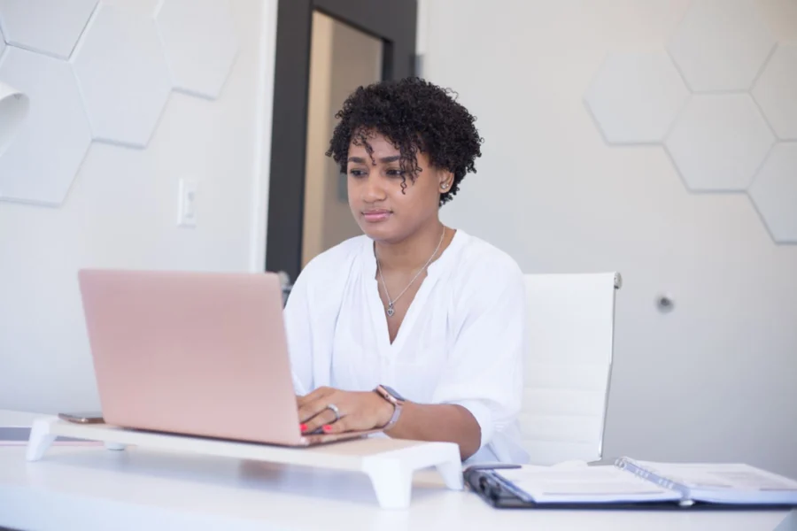 Eine Frau arbeitet an ihrem Laptop am Schreibtisch